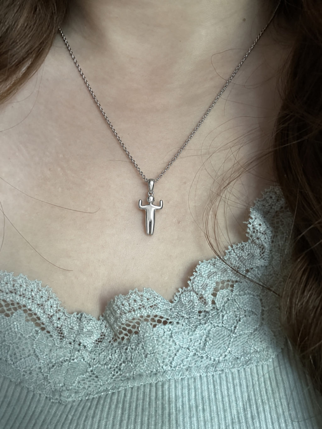 Close view of the Open Arms Figure Pendant worn on a fine silver chain