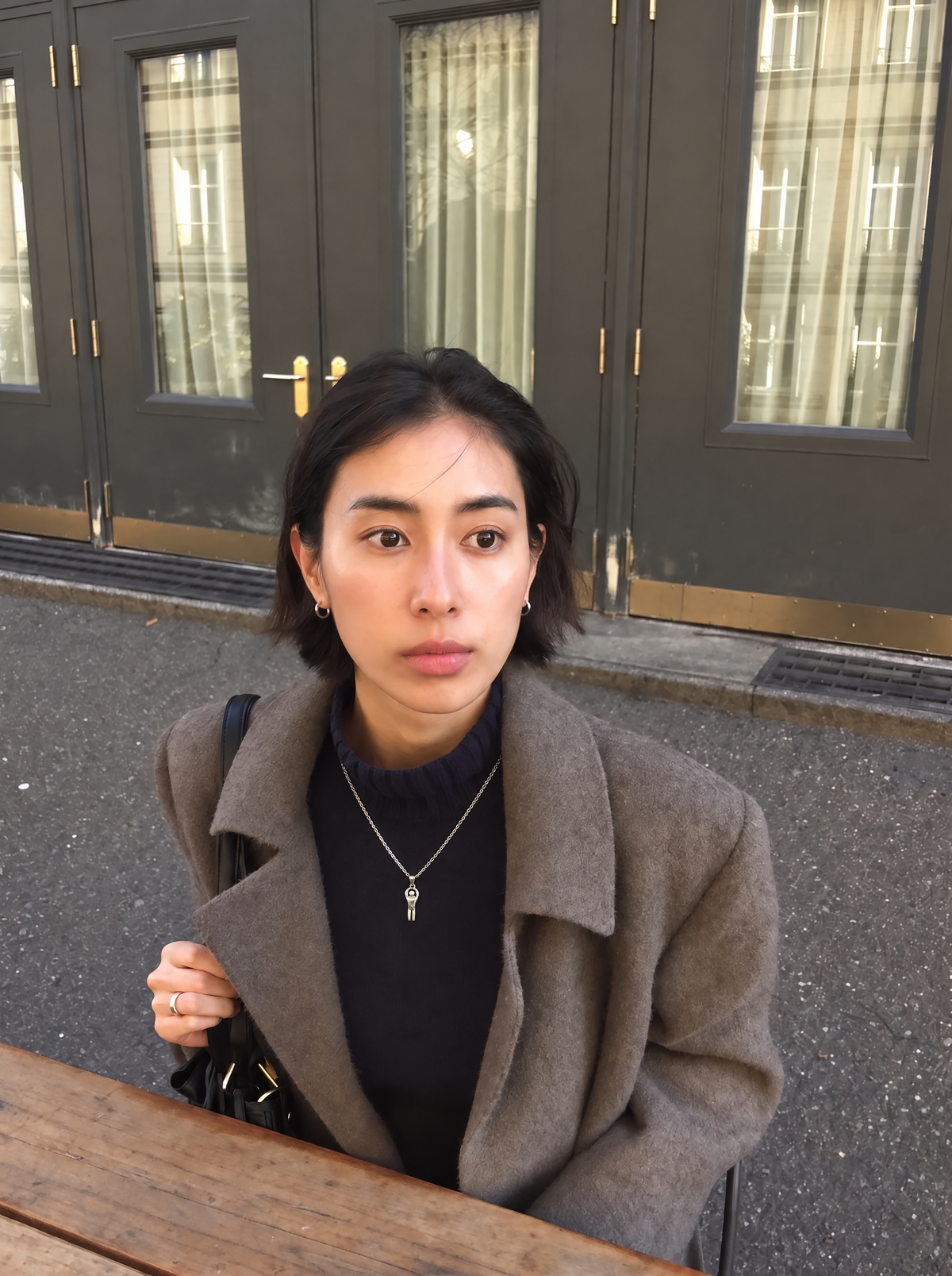 A model wearing the Reaching Figure Pendant on a fine silver chain