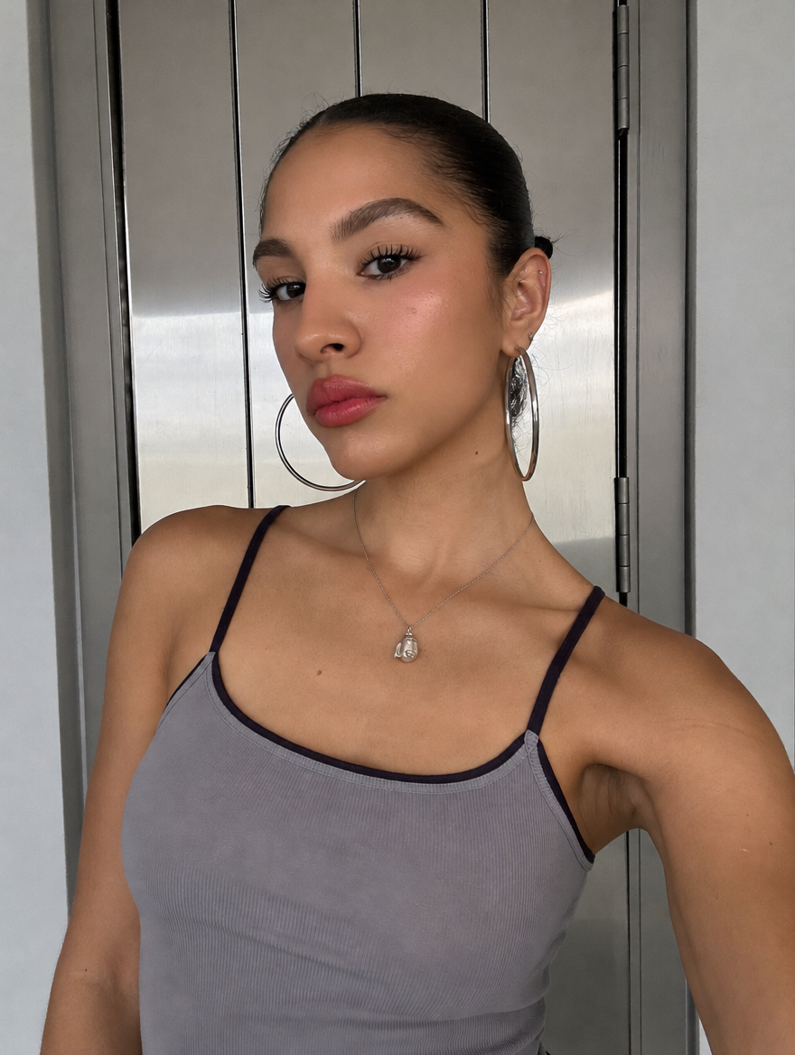 A model wearing the Behelit Egg pendant on a fine silver chain